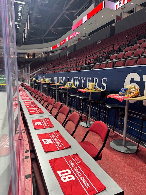 A row of red chairs in a stadium and snacks over small tables